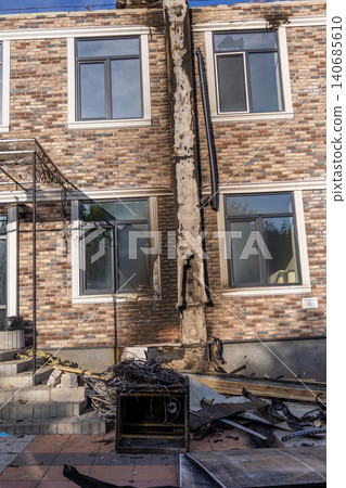 Bila Tserkva, Kyiv region, Ukraine - 09.06.2025: Name Facade of modern brick building damaged by fire and explosion with charred wall shattered window glass and destroyed utility pipe outside Bila Tserkva, Kyiv region, Ukraine - 09.06.2025: Name Facade of modern brick building damaged by fire and explosion with charred wall shattered window glass and destroyed utility pipe outside 140685610