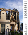 Bila Tserkva, Kyiv region, Ukraine - 09.06.2025: Modern residential house completely ruined after fire explosion with collapsed roof charred walls and empty shattered window frames against blue sky 140685614