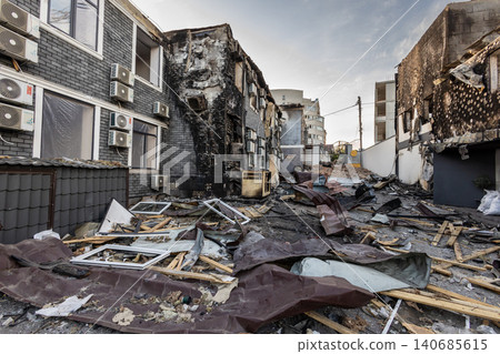 Bila Tserkva, Kyiv region, Ukraine - 09.06.2025: Destroyed city street full of scattered debris and ruined brick buildings with charred black walls after devastating fire explosion Bila Tserkva, Kyiv region, Ukraine - 09.06.2025: Destroyed city street full of scattered debris and ruined brick buildings with charred black walls after devastating fire explosion 140685615