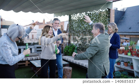 Senior friends enjoying rooftop party dancing and drinking Senior friends enjoying rooftop party dancing and drinking 140685837