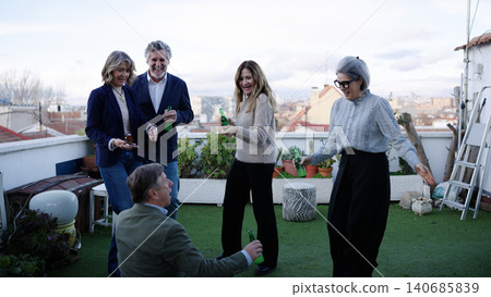 Senior friends enjoying social gathering with drinks on rooftop Senior friends enjoying social gathering with drinks on rooftop 140685839