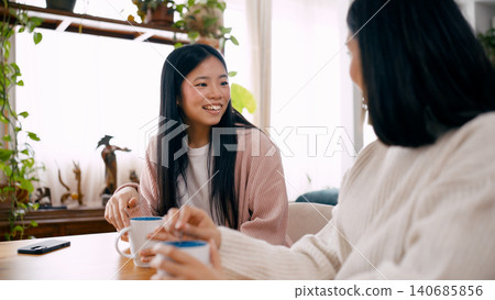 Young woman smiling enjoying conversation over coffee Young woman smiling enjoying conversation over coffee 140685856