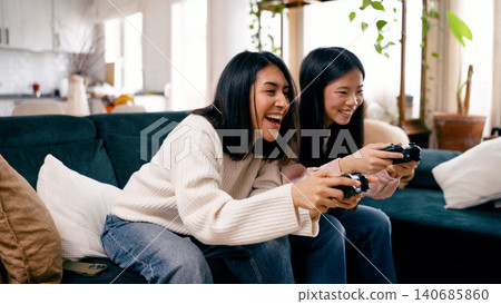 Friends enjoying fun video game competition at home Friends enjoying fun video game competition at home 140685860