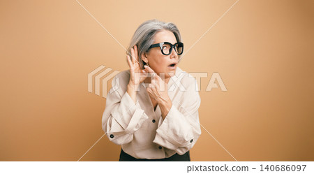 Senior woman struggling with hearing loss and listening Senior woman struggling with hearing loss and listening 140686097
