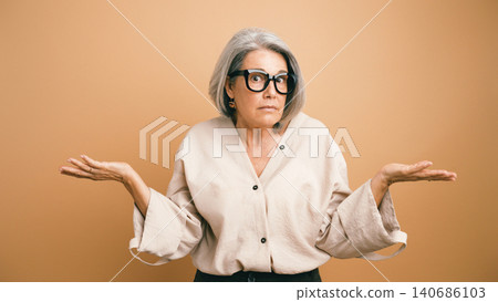 Senior woman shrugging with confused expression Senior woman shrugging with confused expression 140686103
