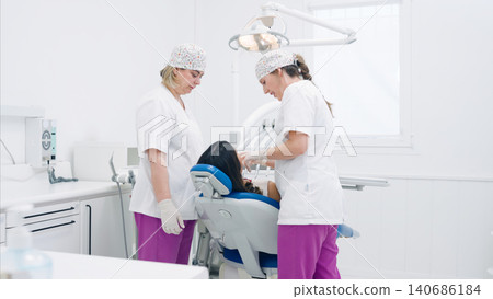 Dentist and dental assistant examining patient in clinic Dentist and dental assistant examining patient in clinic 140686184