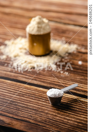 Sports supplements on a wood table background. Vertical composition with protein and creatine. Sports supplements on a wood table background. Vertical composition with protein and creatine. 140686201