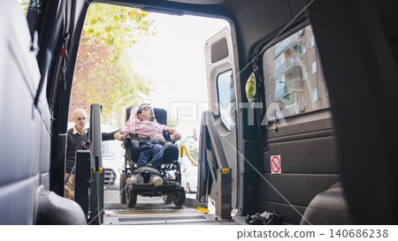 Man in wheelchair using accessible van lift Man in wheelchair using accessible van lift 140686238