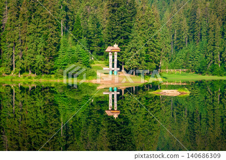 landscape with mountain lake of synevyr national park. green carpathian nature scenery in summer. coniferous forest reflection on the water. popular travel destination of ukraine in the afternoon landscape with mountain lake of synevyr national park. green carpathian nature scenery in summer. coniferous forest reflection on the water. popular travel destination of ukraine in the afternoon 140686309