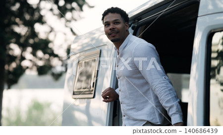 Smiling man enjoying camper van adventure and nature 140686439