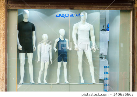 Jeddah, Saudi Arabia - Mar 08 2023, a four mannequins, two adults and two children, stand on showcase in different outfits, Jeddah, Saudi Arabia 140686662
