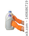 two canisters with liquid laundry detergent in gloved hands 140686719