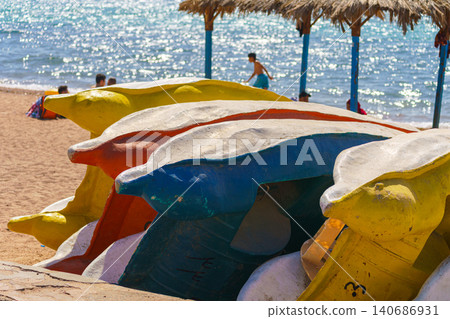 Aqaba, Jordan, a close up view of several colourful catamarans folded on one side on the beach, at daytime Aqaba, Jordan, a close up view of several colourful catamarans folded on one side on the beach, at daytime 140686931