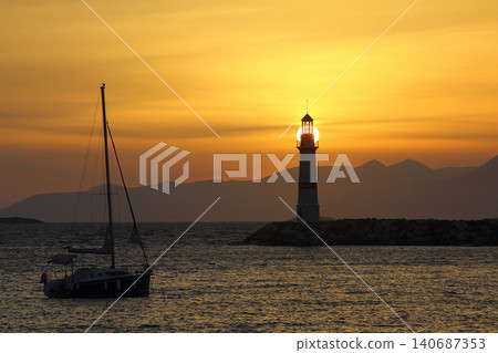 Seascape at sunshine. Lighthouse and sailings on the coast. Seaside town of Turgutreis and spectacular sunshine Seascape at sunshine. Lighthouse and sailings on the coast. Seaside town of Turgutreis and spectacular sunshine 140687353