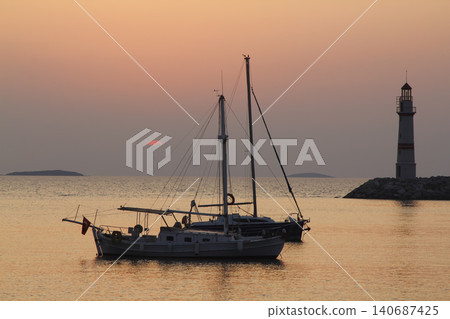 Seascape at sunshine. Lighthouse and sailings on the coast. Seaside town of Turgutreis and spectacular sunshine Seascape at sunshine. Lighthouse and sailings on the coast. Seaside town of Turgutreis and spectacular sunshine 140687425