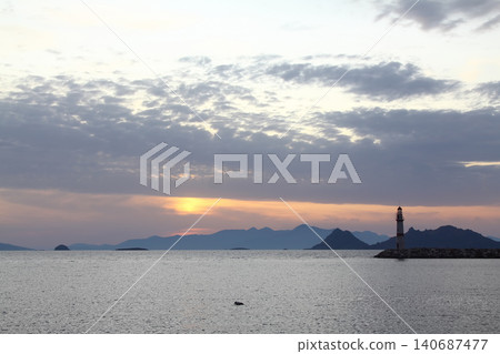 Seascape at sunshine. Lighthouse and sailings on the coast. Seaside town of Turgutreis and spectacular sunshine Seascape at sunshine. Lighthouse and sailings on the coast. Seaside town of Turgutreis and spectacular sunshine 140687477