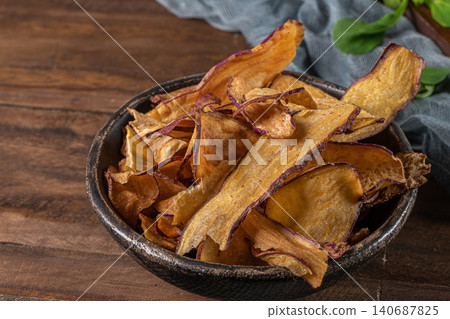 Delicious sweet potato chips in bowl,  on table 140687825