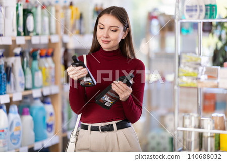 Young woman chooses ceramic and induction cleaner in store Young woman chooses ceramic and induction cleaner in store 140688032