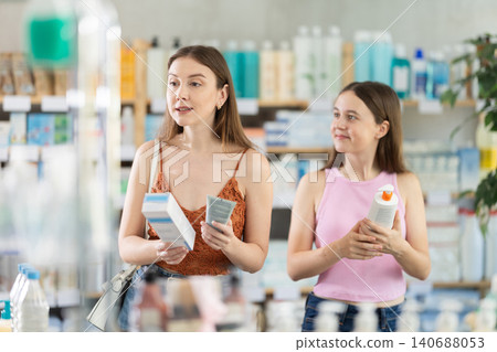 Woman with daughter choosing cream in pharmacy 140688053