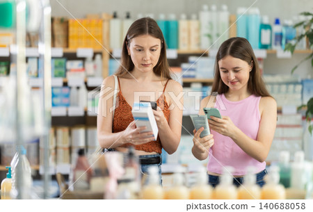 Woman with daughter scanning qr code of cream Woman with daughter scanning qr code of cream 140688058