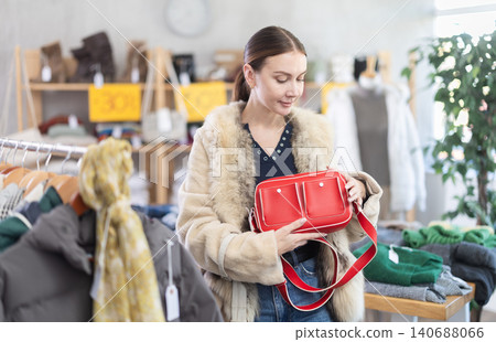Adult woman choosing handbag in clothing store Adult woman choosing handbag in clothing store 140688066