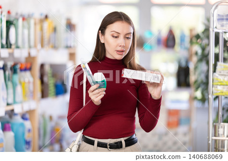 Woman choosing toothpaste in supermarket Woman choosing toothpaste in supermarket 140688069