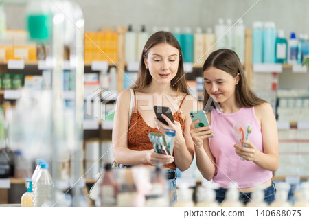 Mom and daughter scan toothbrush barcode on phone Mom and daughter scan toothbrush barcode on phone 140688075