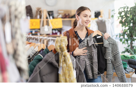 Young woman choosing a coat in a store 140688079