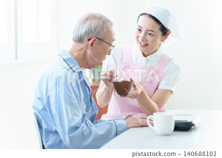 Helpers who assist elderly people with meals 140688101