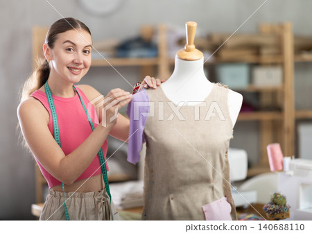 Tailor connects parts of dress on mannequin Tailor connects parts of dress on mannequin 140688110