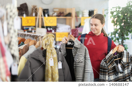 Teenage girl chooses coat in clothing store 140688147