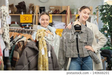 Teen girl with mother choosing something for autumn-winter in clothing store 140688201