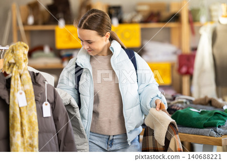 Teenage girl chooses outerwear in store 140688221