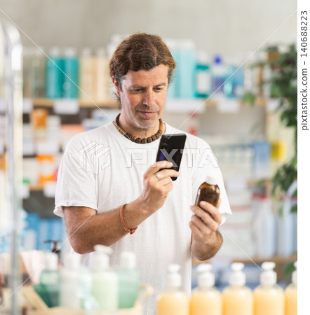 Man scans for mobile medicinal syrup in pharmacy 140688223