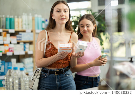 Woman with teen girl are busy choosing tablet pills at pharmacy Woman with teen girl are busy choosing tablet pills at pharmacy 140688322