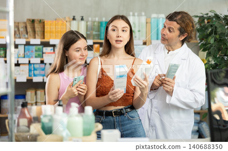 Woman with teen girl choosing and scan QR code cream at pharmacy Woman with teen girl choosing and scan QR code cream at pharmacy 140688350