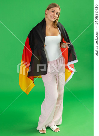 Teenage girl holding Germany flag in front of green screen Teenage girl holding Germany flag in front of green screen 140688430
