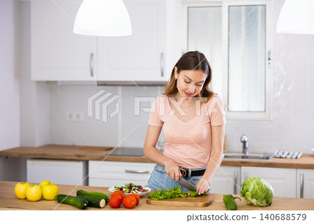 Portrait of woman cutting vegetable on kitchen 140688579