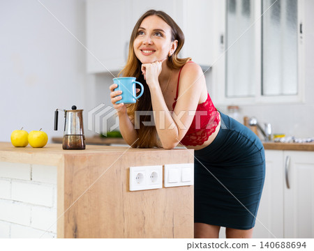 Woman drinking coffee at kitchen in morning 140688694