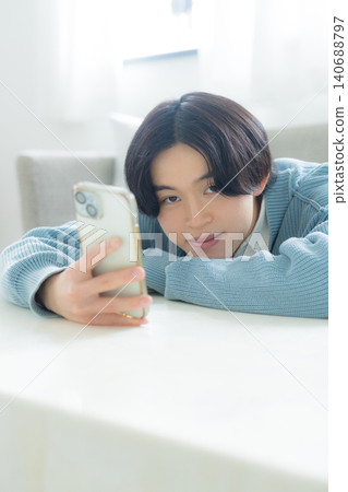 A young man operating a smartphone 140688797