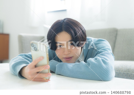 A young man operating a smartphone 140688798