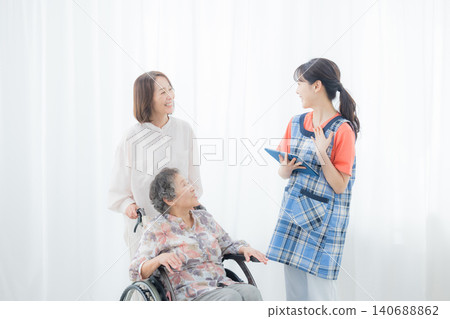A caregiver using a tablet and an elderly person in a wheelchair A caregiver using a tablet and an elderly person in a wheelchair 140688862