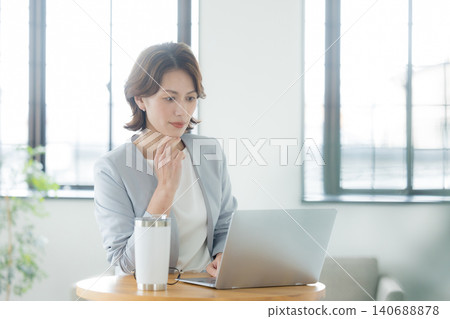 A woman using a computer in the living room A woman using a computer in the living room 140688878