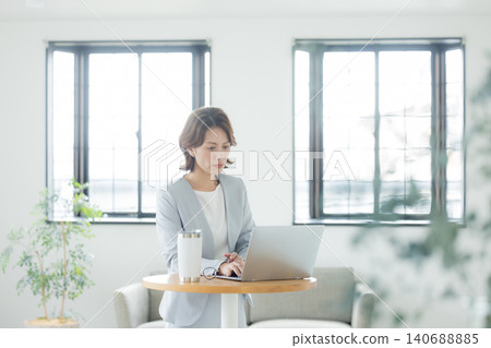 一位女士在客廳使用電腦 140688885