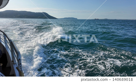 Scenic ocean view from a boat with splashing waves and distant islands. Scenic ocean view from a boat with splashing waves and distant islands. 140689018