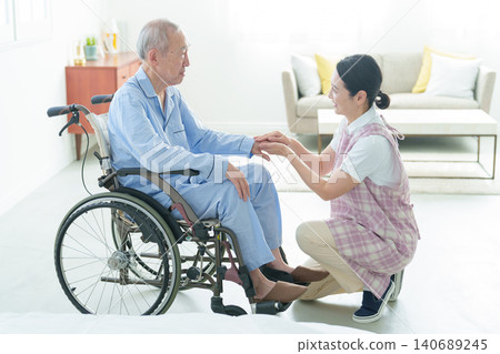 Caregivers assisting elderly people in wheelchairs Caregivers assisting elderly people in wheelchairs 140689245