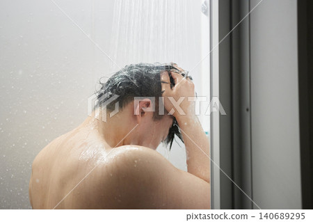 A man in his twenties taking a shower A man in his twenties taking a shower 140689295