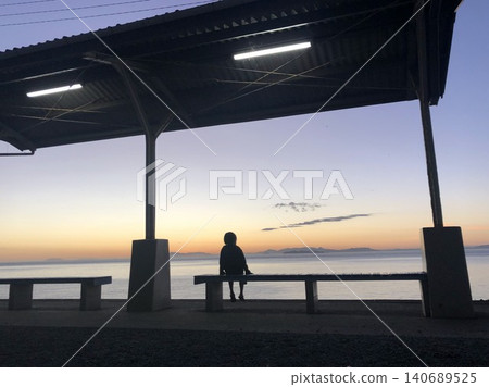 A silhouette of a person sitting at a seaside station at dusk - Shimonada Station A silhouette of a person sitting at a seaside station at dusk - Shimonada Station 140689525