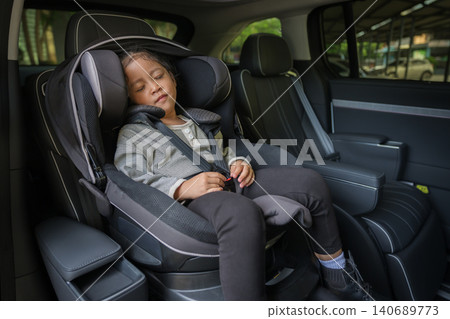 preschool child girl sitting and sleeping in car seat, safety baby chair travelling 140689773
