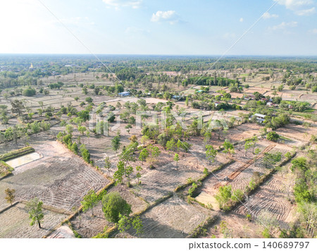 Patchwork farm fields and agricultural land in rural countryside. Cultivated plots, natural vegetation, and expansive horizon during the dry season. Sustainable agriculture and rural development. Patchwork farm fields and agricultural land in rural countryside. Cultivated plots, natural vegetation, and expansive horizon during the dry season. Sustainable agriculture and rural development. 140689797
